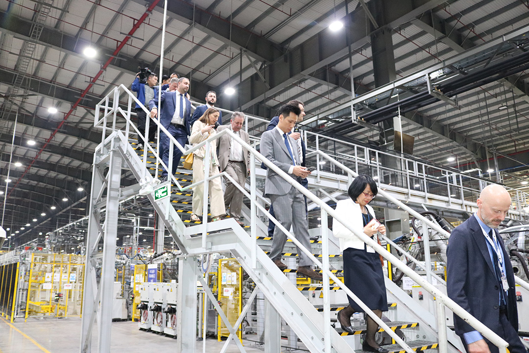 A group of Vietnamese and Belgians visitors on a factory staircase