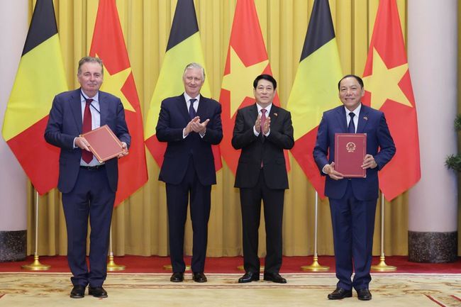 H.M. King Philippe, H.E. Lương Cường, President of Vietnam, Rudi Vervoort, Minister-President of the BCR and Nguyễn Văn Hưng, Vietnamese Minister of Culture, pose in front of Belgian and Vietnamese flags.