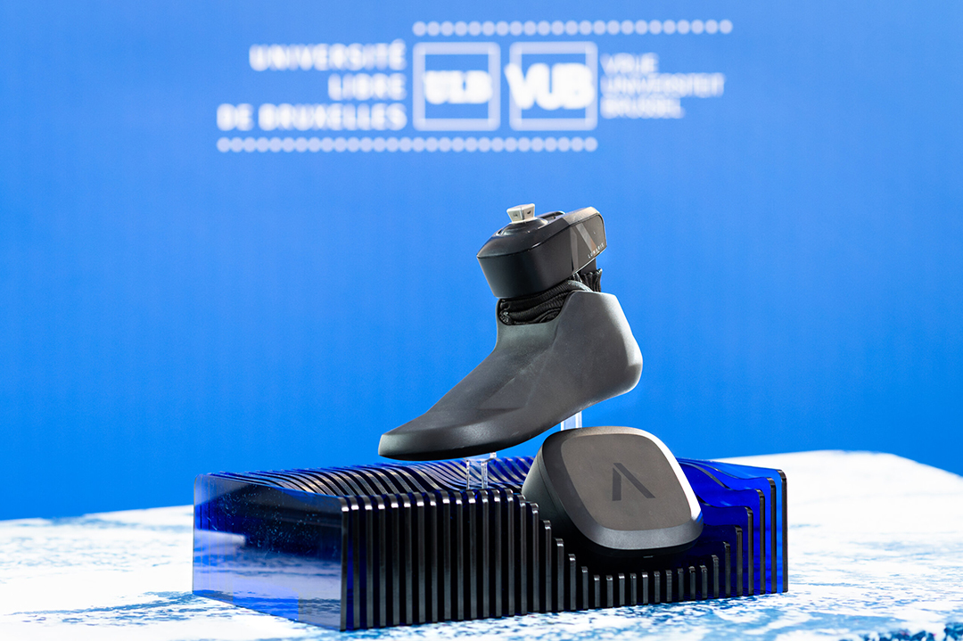 A prosthetic foot displayed on a blue base