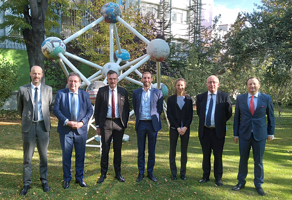 The delegation in the garden of the Ambassador’s residence standing in front of a reproduction of the Atomium