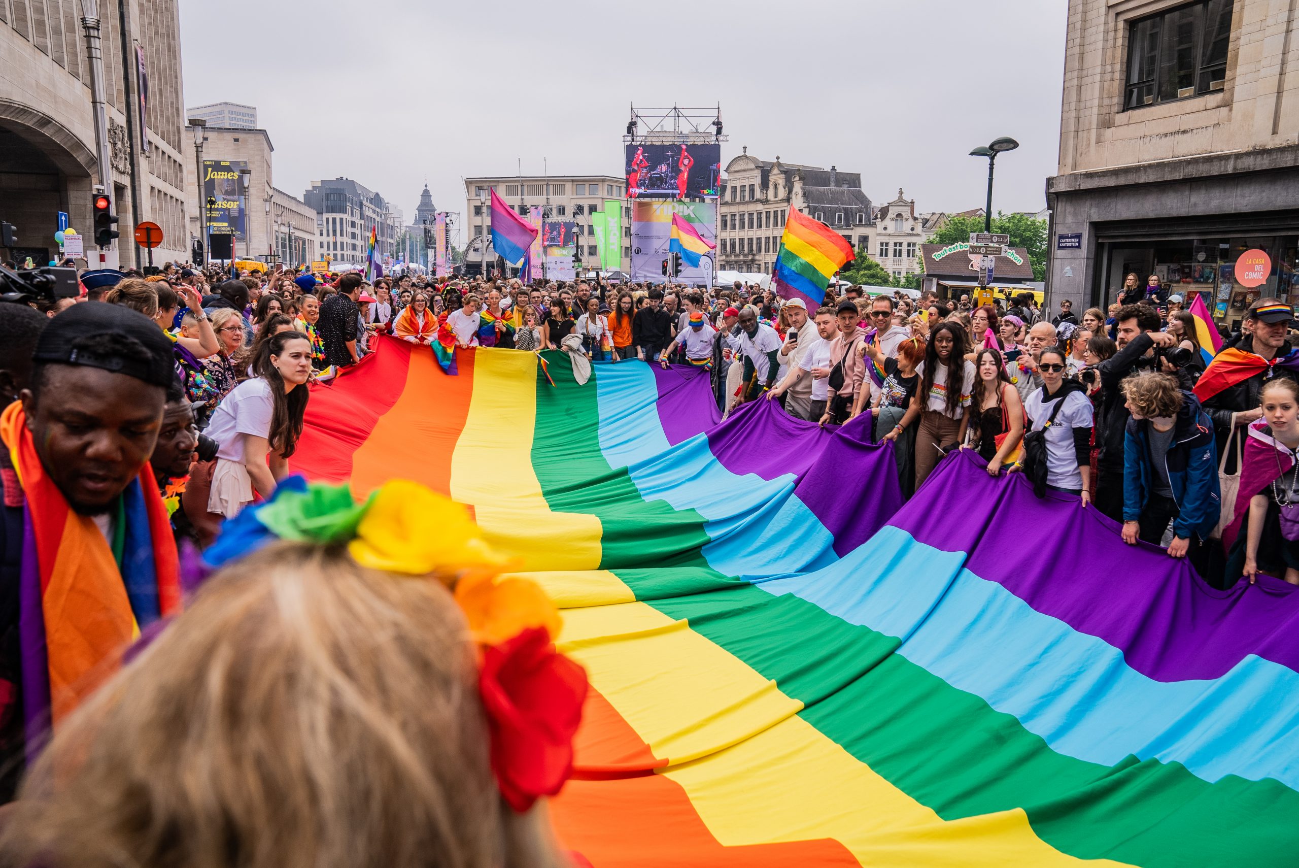 Des participants à la Pride tiennent un énorme drapeau arc-en-ciel