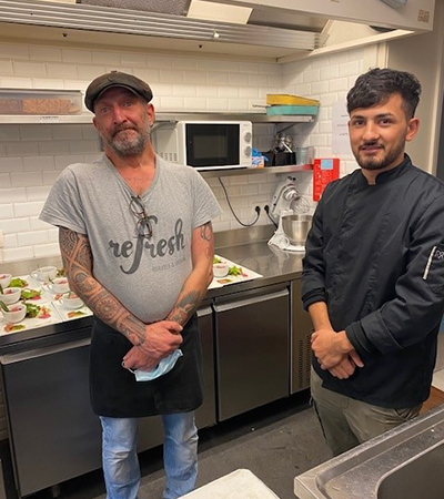 Two employees standing in the kitchen