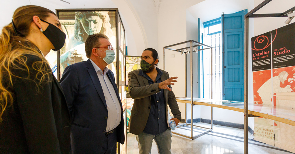 Rudi Vervoort visite l’exposition avec Orlando Inclán et une troisième personne.