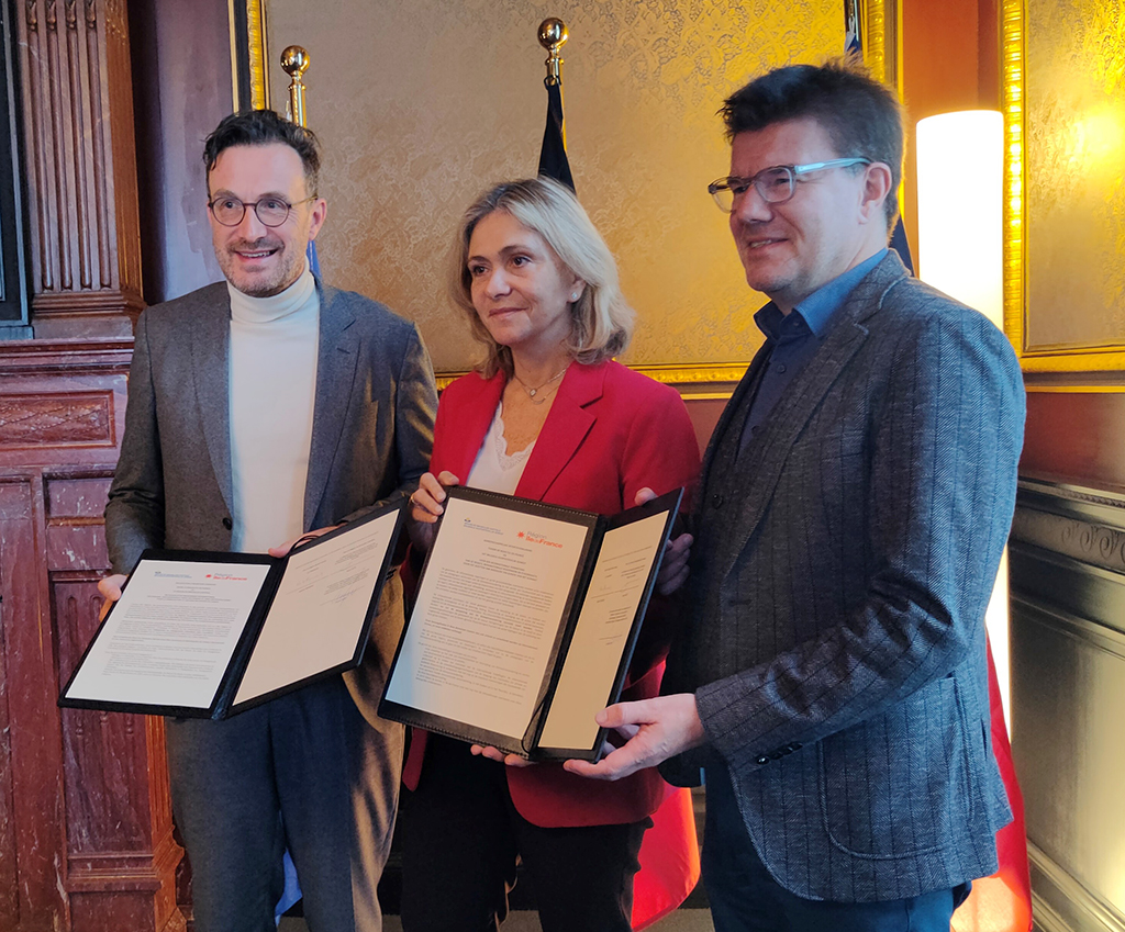 The signatories pose, standing, with the signed document