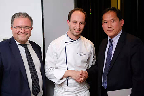 Maxime Maziers, flanked by Christian Lamouline, shakes the hand of Yin Fei.