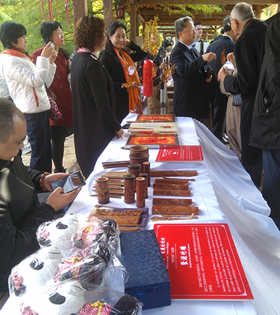 The Chinese representatives display traditional hand-crafted products on a table.
