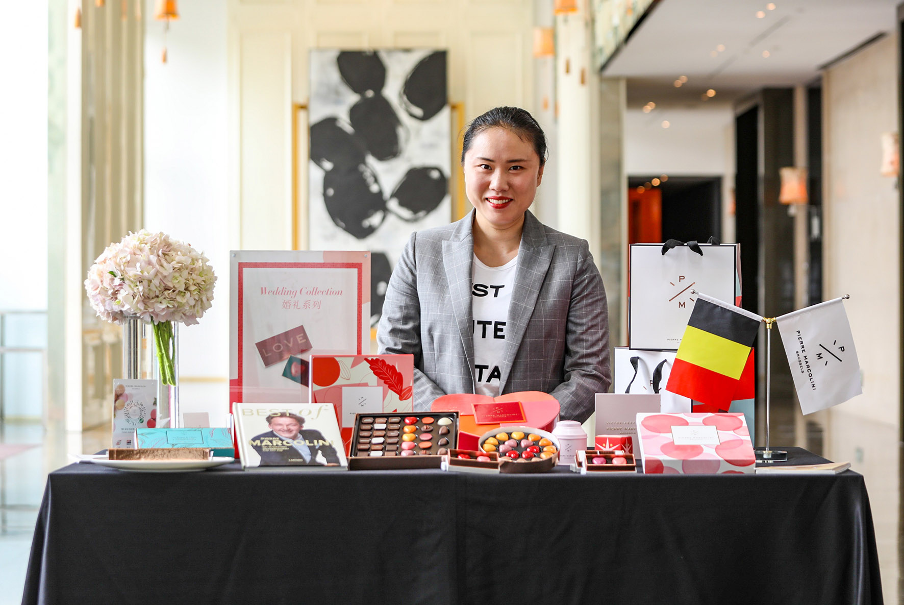 A Chinese woman standing behind a table with boxes of chocolate 