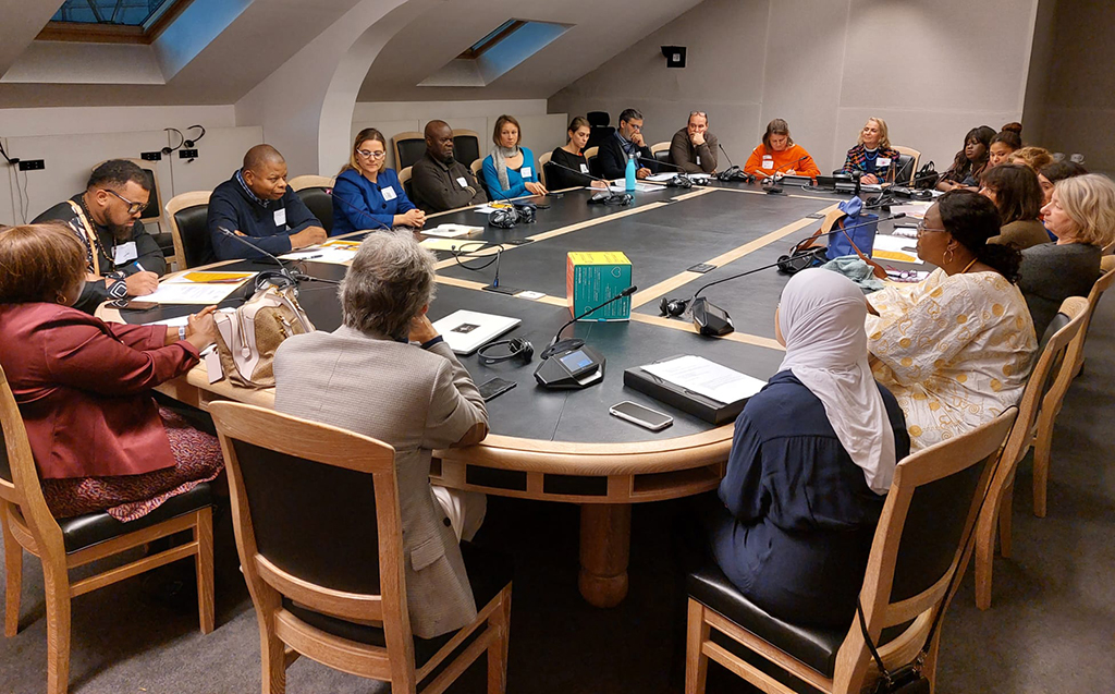 The participants are seated around a table during the meeting.