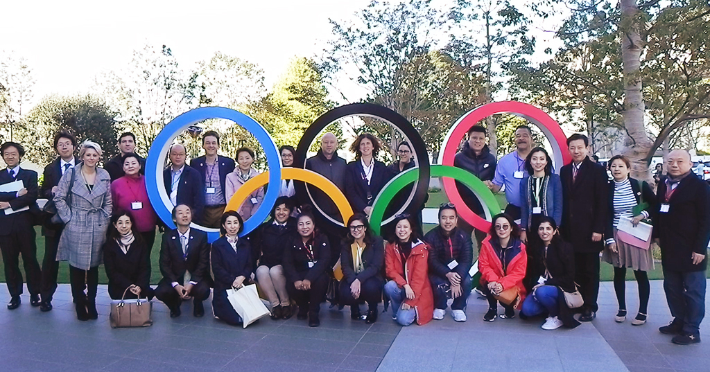 The participants pose around the Olympic rings.