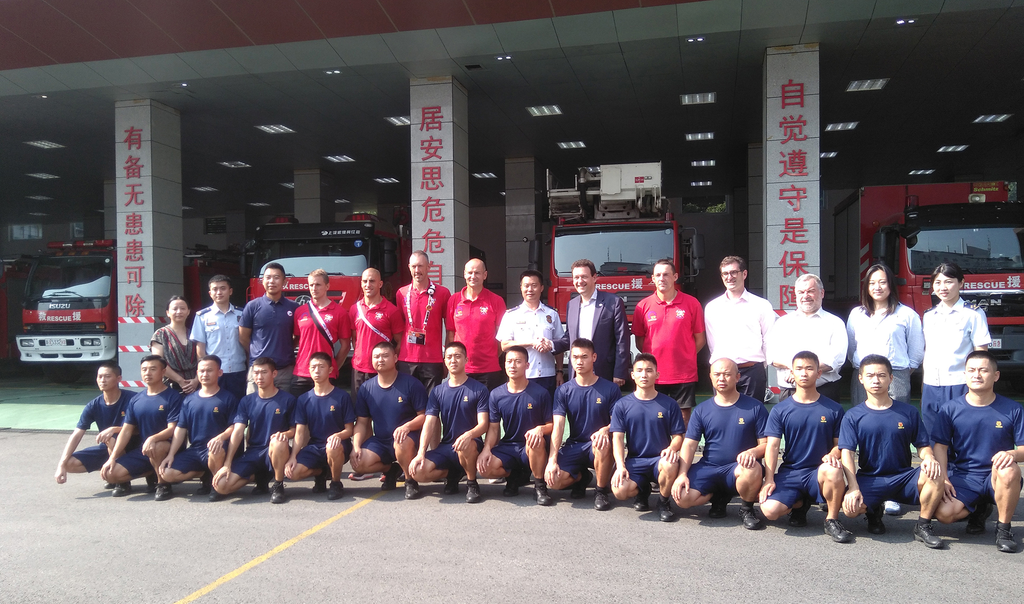 The Brussels and Chinese firemen pose in front of the fire station.