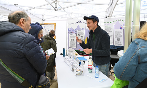 Visitors talking to an employee at the booth 