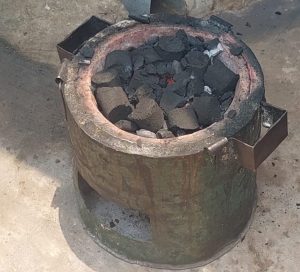 Plusieurs briquettes brûlent dans un récipient en fonte et produisent de la chaleur