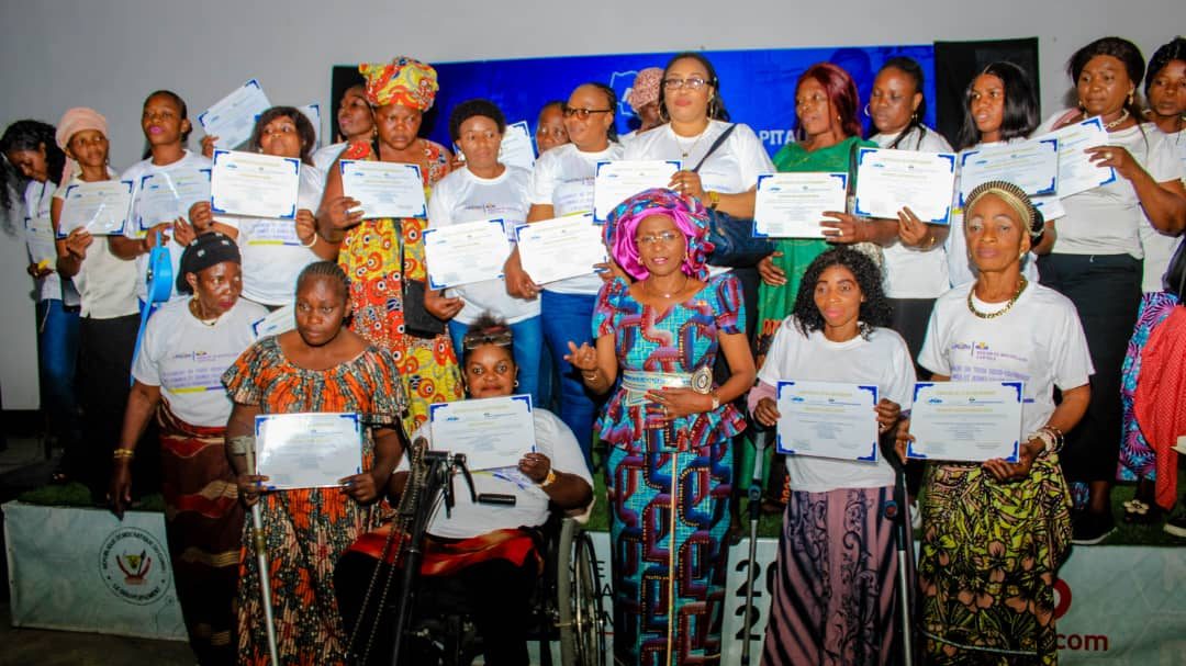 Des femmes posent devant l'appareil photo avec leur certificat en main